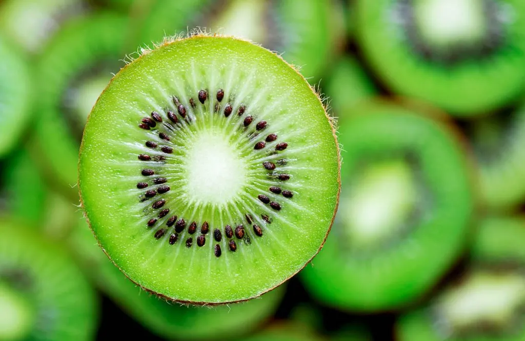 closeup image of green kiwi slice and seeds