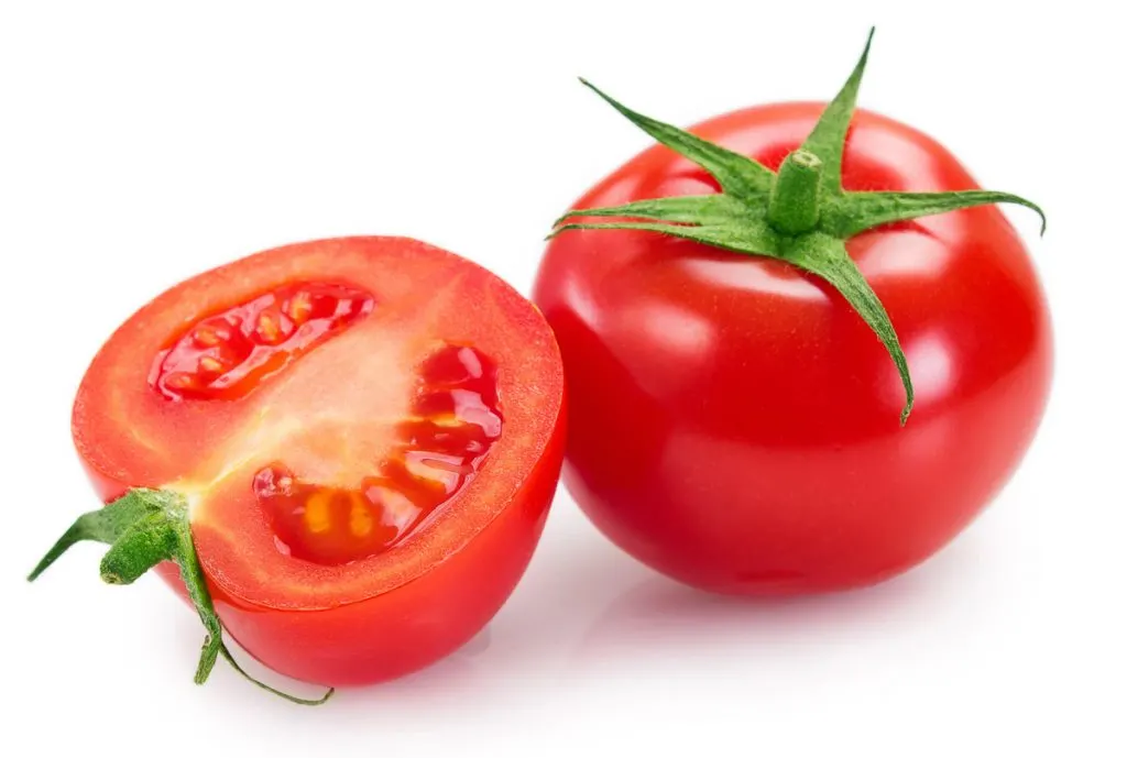 two red tomatoes split in half on white background